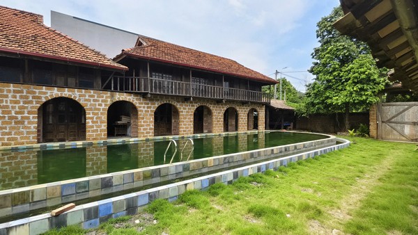 Hàng vòm đá soi bóng bên hồ nước và thảm cỏ