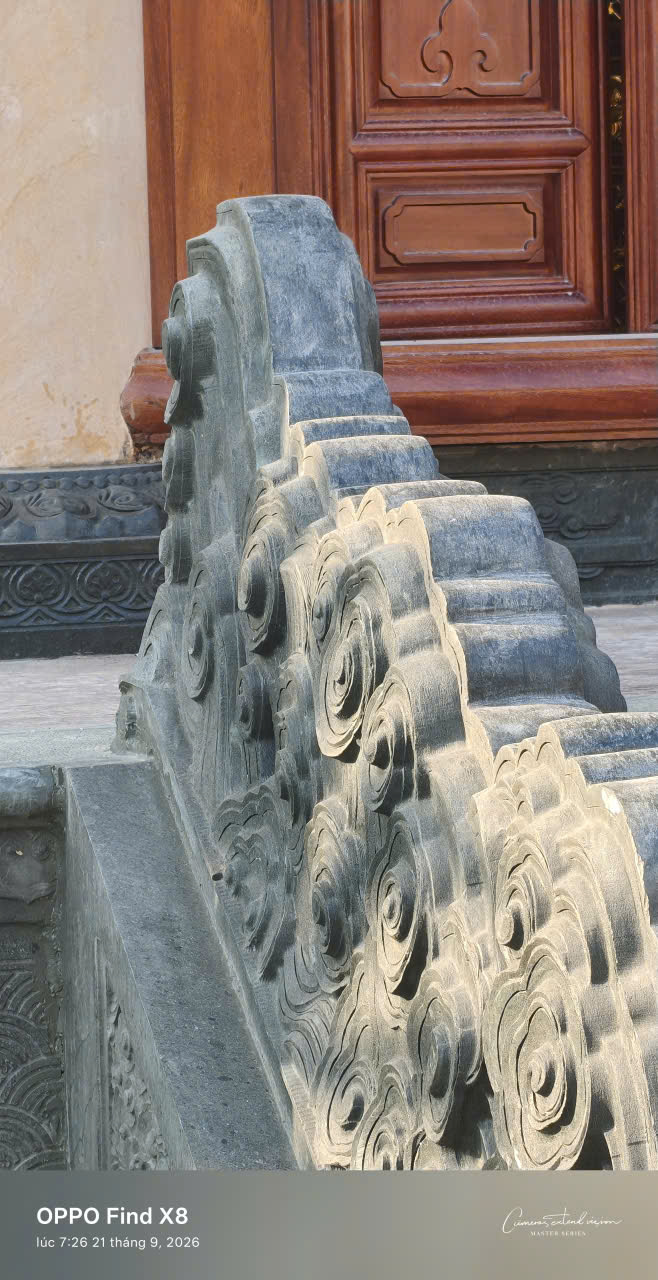 Chi tiết khúc thân rồng đá bên thềm cửa gỗ